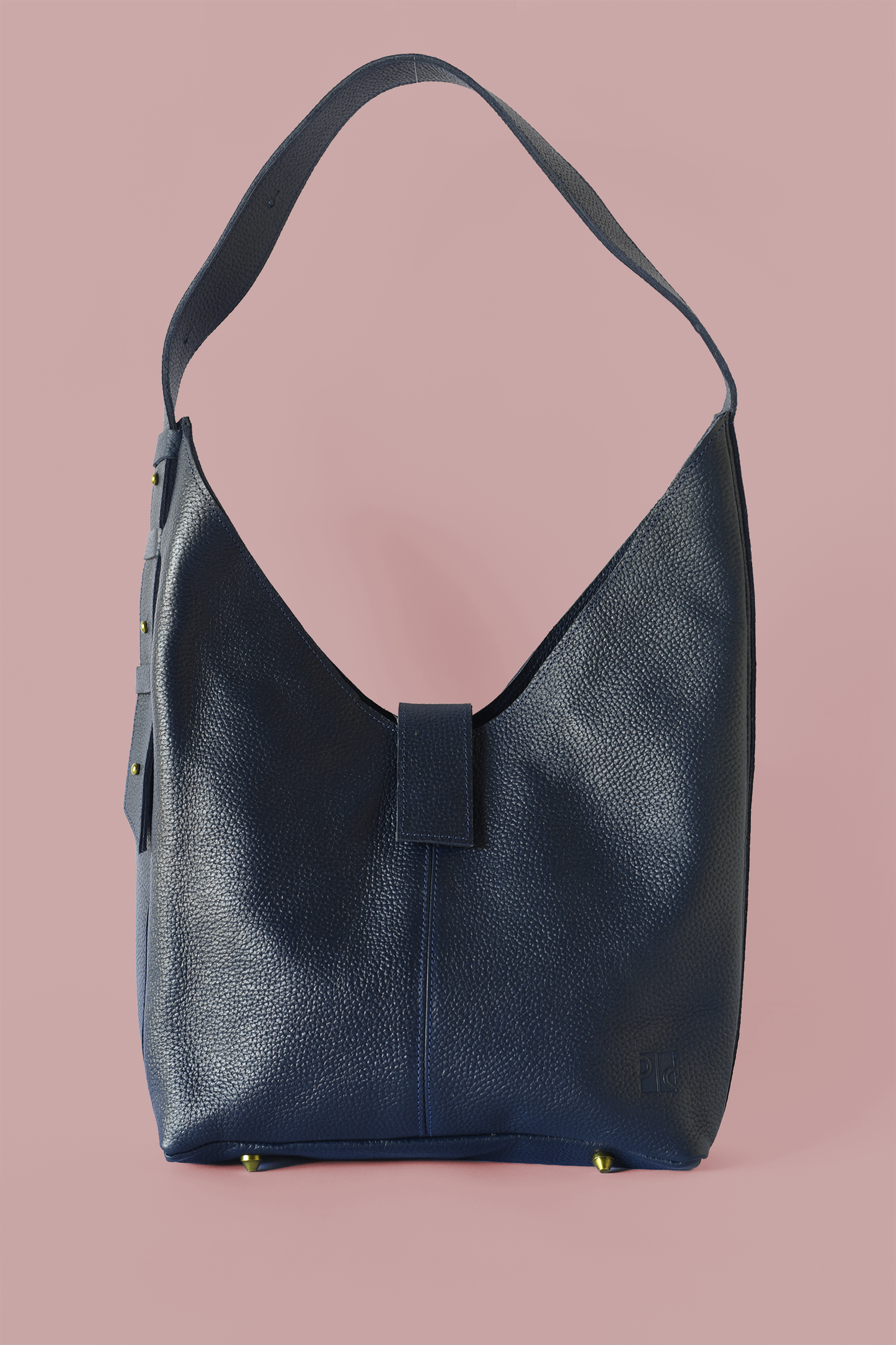 Blue pebbled leather shoulder handbag on a pink background