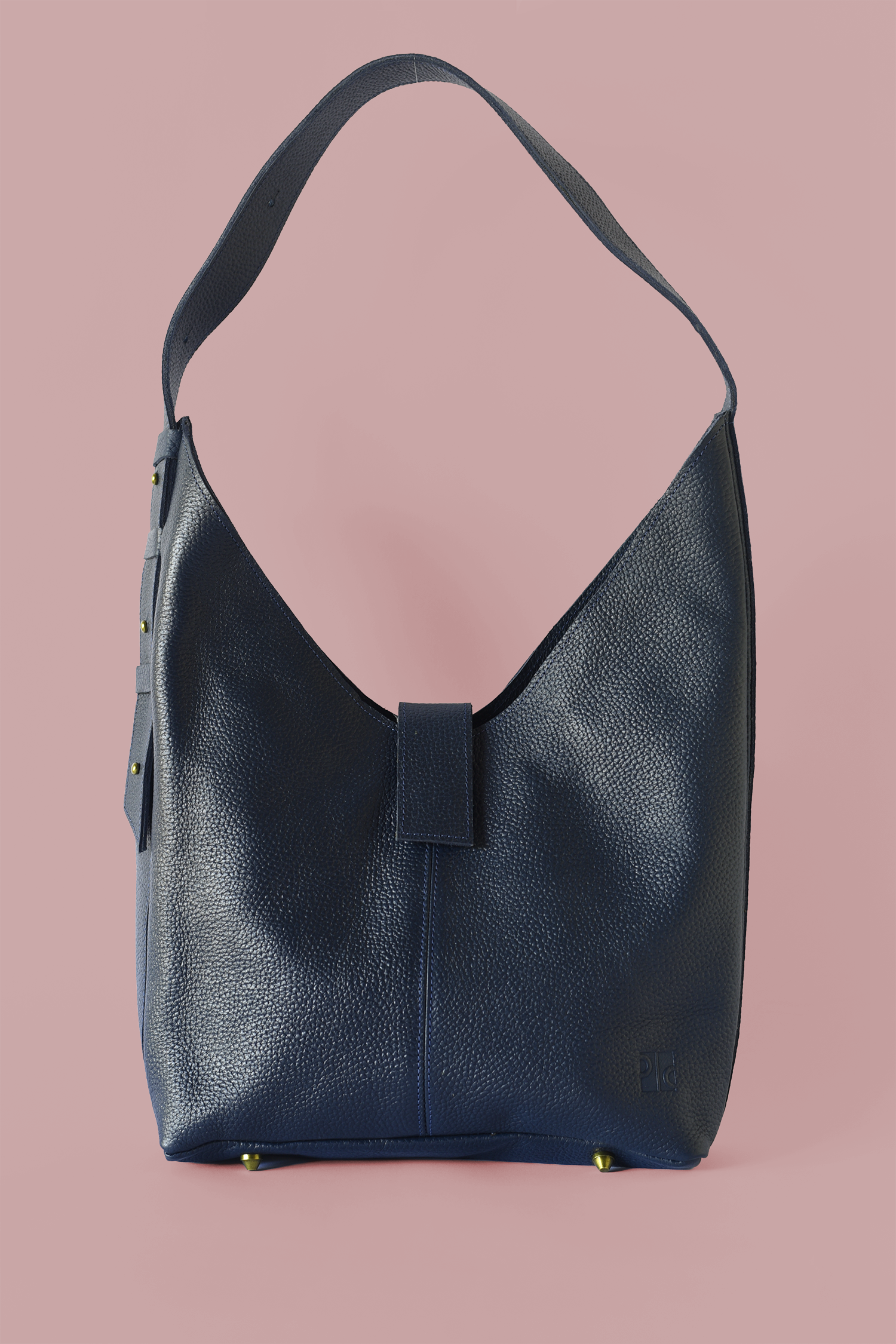Blue pebbled leather shoulder handbag on a pink background